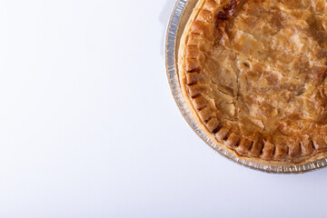 Directly above shot of baked stuffed pie in plate on white background with copy space