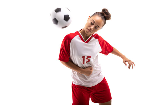 Biracial young female soccer player hitting soccer ball with shoulder while playing soccer