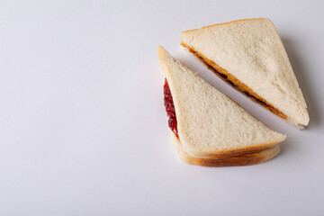 Close-up of halved peanut butter and jelly sandwich over white background with copy space
