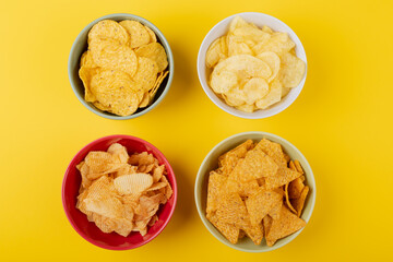 Directly above shot of various snacks in bowls on yellow background