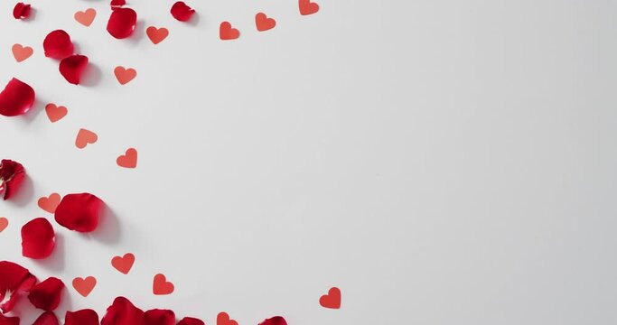 Paper hearts and petals on white background at valentine's day