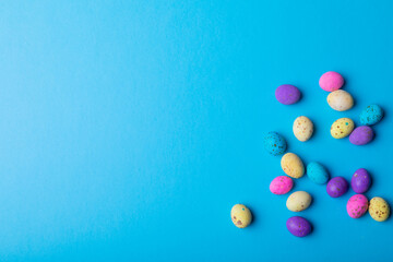 Overhead view colorful eater candies on blue background with copy space