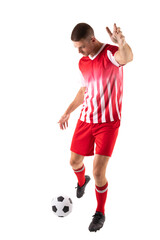 Full length of young male caucasian athlete kicking soccer ball against white background