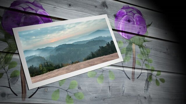 Photograph of landscape with woods and mountains against floral print on wooden background