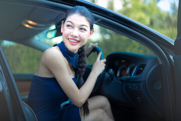 Naklejka premium Beautiful woman driving a luxury car and using electric cars to save energy.