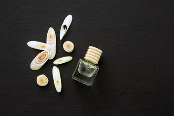 Fresh lemongrass slices and lemon grass oil bottle on black background , top view , flat lay.