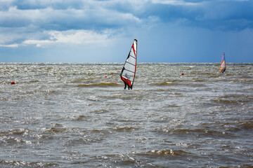 Windsurfing.Windsurfers have fun on the water against a stormy sky.