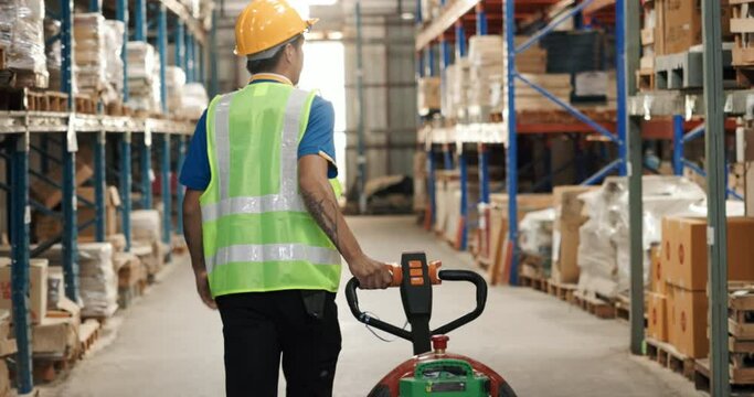 Asian man, manual worker use hand to pull, drag or lug pallet jack in warehouse, store for management, organization box on shelf or racking. Concept for industry, distribution, inventory, shipping.
