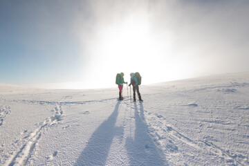 Two women walk in snowshoes in the snow