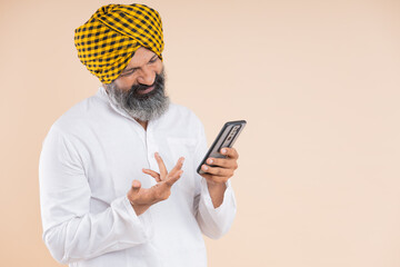 portrait of happy  indian Sikh farmer using mobile 