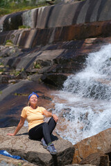 Fototapeta na wymiar girl tourist admiring the waterfall in Ergaki nature park