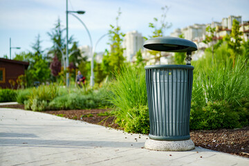 Green metal trash bin in a city