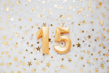 Number 15 fifteen golden celebration birthday candle on Festive Background. fifteen years birthday....