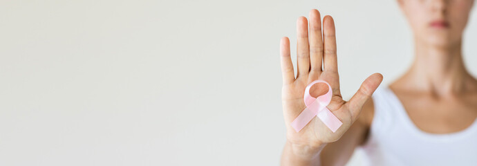 Woman with pink ribbon symbol of breast cancer awareness month. Horizontal long banner for web...