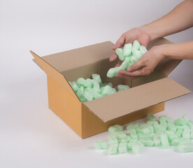 woman hand putting shockproof foam into the corrugated parcel box, online business concept. 