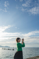 海で撮影するカメラ女子