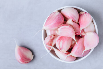 Garlic. Fresh harvested organic garlic cloves bulb in bowl on gray stone background.