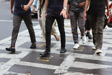 close-up of unidentified people legs crossing street.