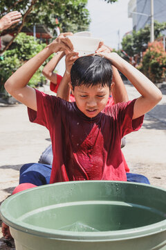 Tradition of celebrating Indonesian Independence Day, kid playing games to give water to their groups without looking back