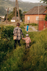 Obraz premium Mother with her little son in the park for a walk in summer. Active lifestyle with the baby in the summer.