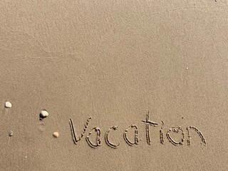 on the beach is carved with letters in the smooth sand the writing vacation