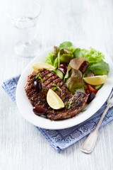 Grilled pork steak with fresh salad. Bright wooden background.