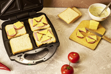 sandwich maker cheese sausage and bread on the table