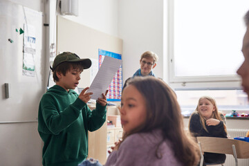 Boy reading in front of class