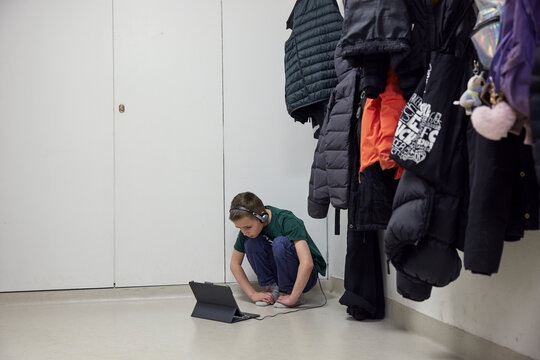Boy using digital tablet in changing room