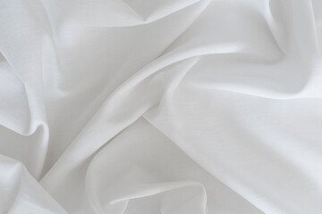White drapery linen fabric background. Texture of the light surface of the fabric.
