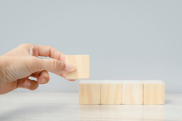 Hand holding arranging wood cube block business development concept. Blank wood cube block background 