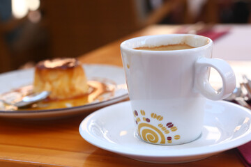 cup of coffee and pudding dessert closeup photo in open air Spanish cafe