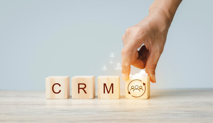 CRM Customer Relationship Management. Hand holding stack wood cube block icon. Internet Technology Concept