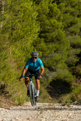 A male cyclist in a gravel road bicycle ride in the  mountains of Costa Blanca, Alicante, Spain