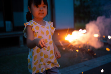 夏休みに家の庭で花火をしている女の子