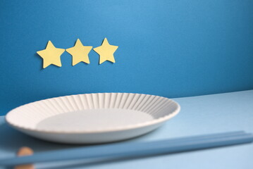 三ツ星と皿と箸と青背景の左寄りのアップ写真