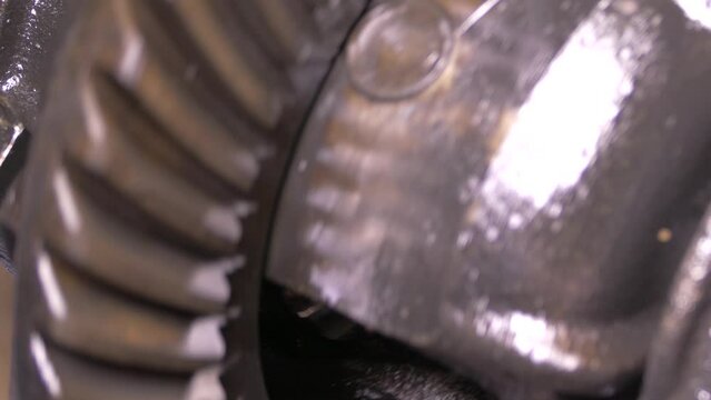 A mechanism with rotating gears. Reducer from the middle. Metal construction from spare parts. Traction rotation transmission. Stopping and starting the engine.