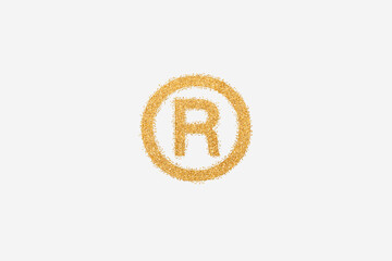 Registered trademark symbol made of golden glitter