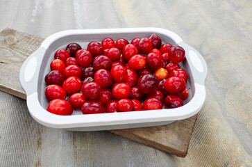 Ripe red cherry plums on plate. Juicy fruit on wooden background, closeup. Fresh plum, vegetarian food