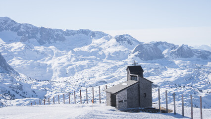Small chapel on a snowy landscape surrounded by mountains, Austria, Europe