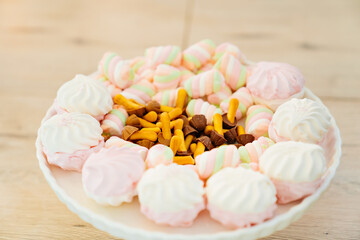 marshmallows and cookies mushrooms with chocolate on a plate.