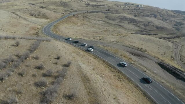 The convoy of cars on roads. Aerial view different cars on curve roads. 