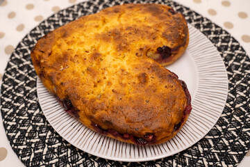 heart shaped homemade cherry pie on white plate on kitchen table. Bakery for loved ones