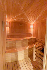 Fototapeta na wymiar seat in sauna room. Empty wooden steam room with stone heater. sauna room for good health. Sauna room with traditional sauna accessories
