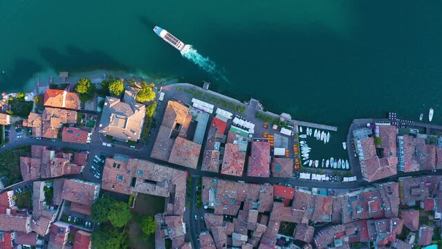 Gargnano at Lake Garda. aerial view. Small marina in Italian village. ferry and boats leaving the harbour. Top view of a cosy Italian fishing village. Port on the edge of Lago di Garda in Brescia