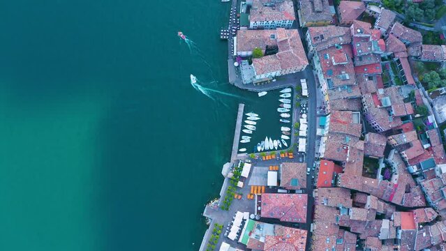 Gargnano at Lake Garda. aerial view. Small marina in Italian village. ferry and boats leaving the harbour. Top view of a cosy Italian fishing village. Port on the edge of Lago di Garda in Brescia