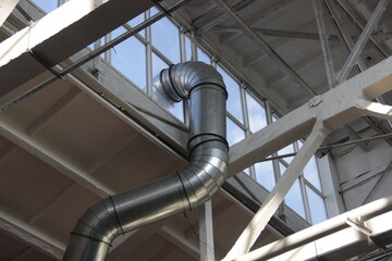 Curved ventilation pipe passing under the roof of the workshop