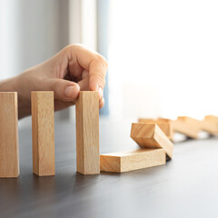 Businesswoman stops hands falling over domino to stop risk continuously, Continuous damage...