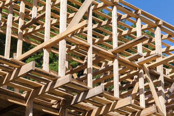 Wooden house frame is under construction, unfinished building