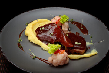 Lamb tongues with mashed potatoes on a wooden background